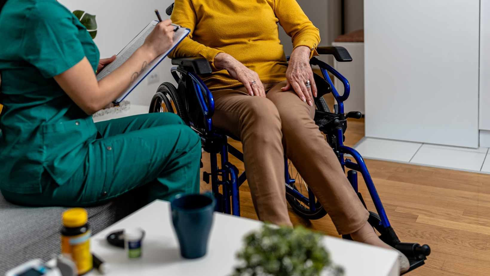 Shot of caregiver speaking to woman in wheelchair